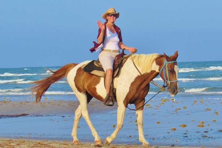 woman riding a horse on the beach